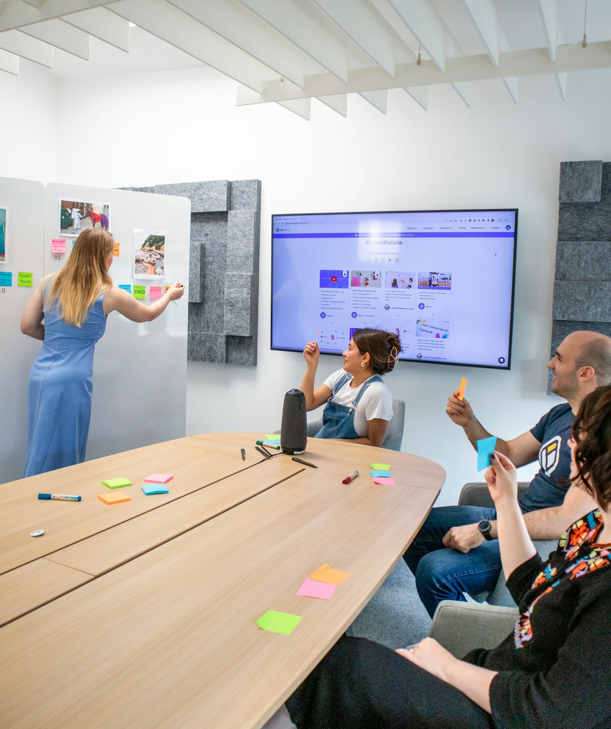 Diverse team brainstorming around a monitor and sticky notes.